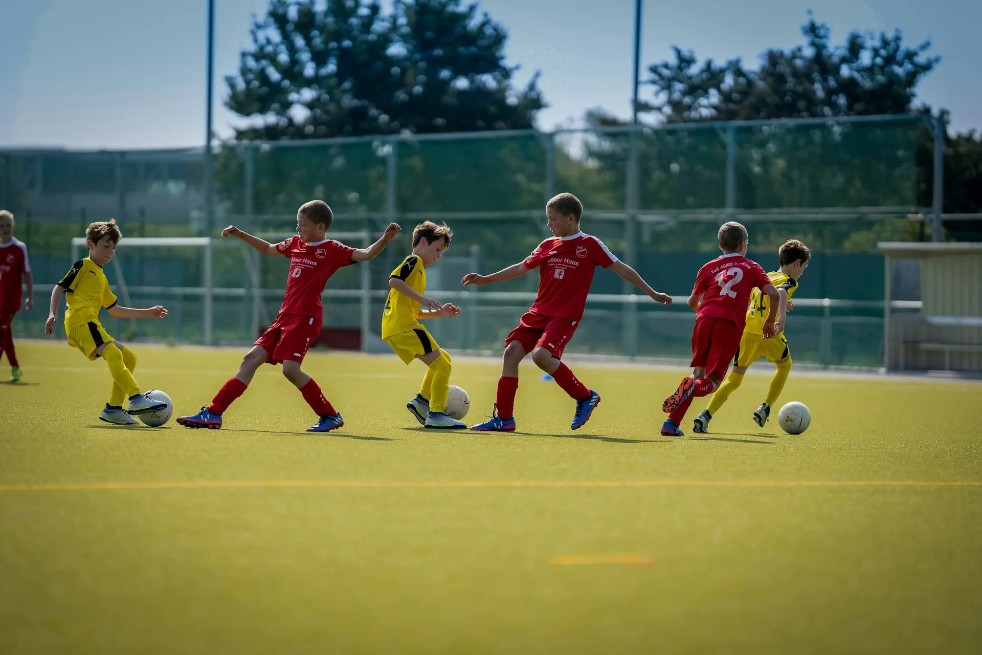 A football match in full flow on a grass pitch.