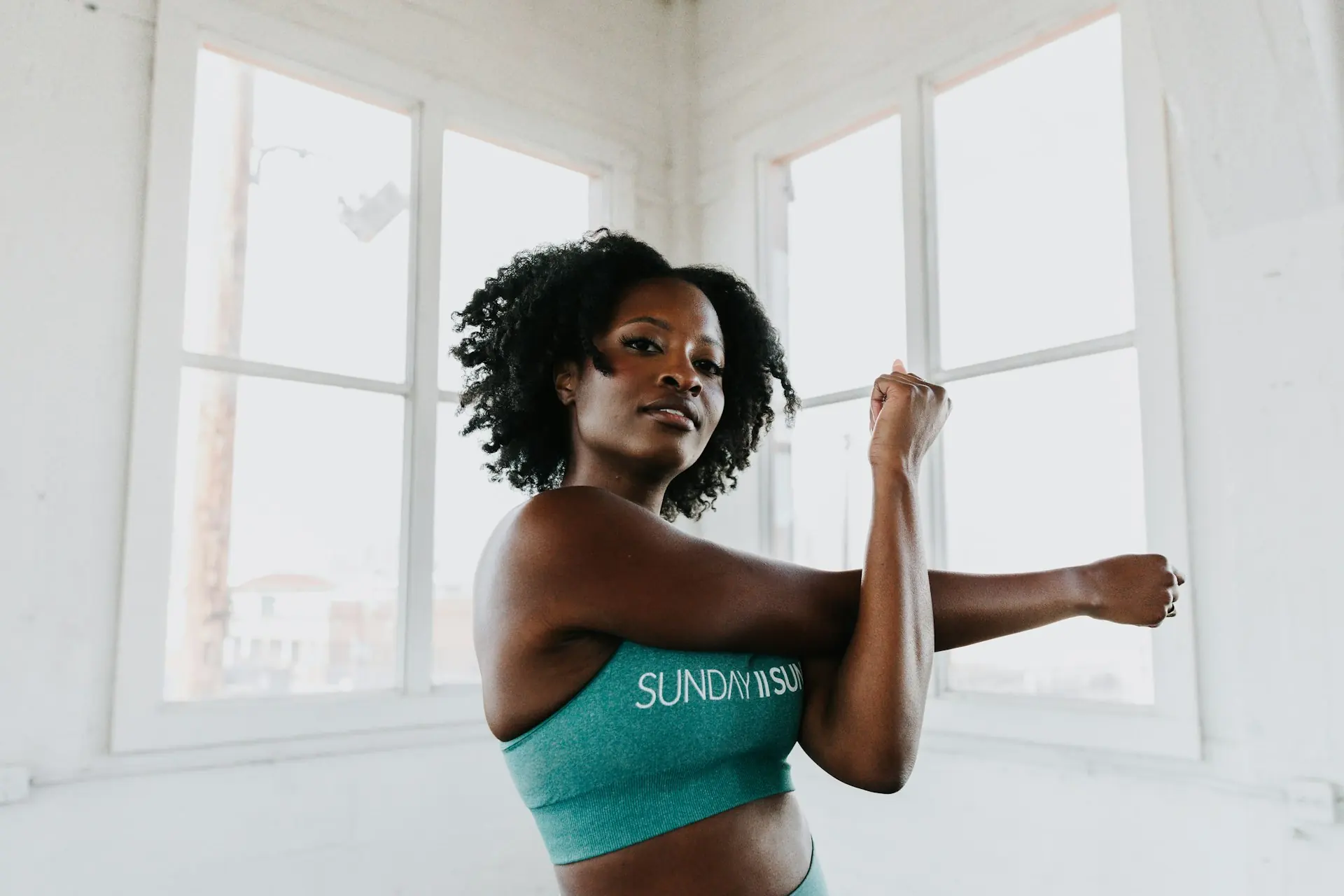 A woman stretching her arms out after training.