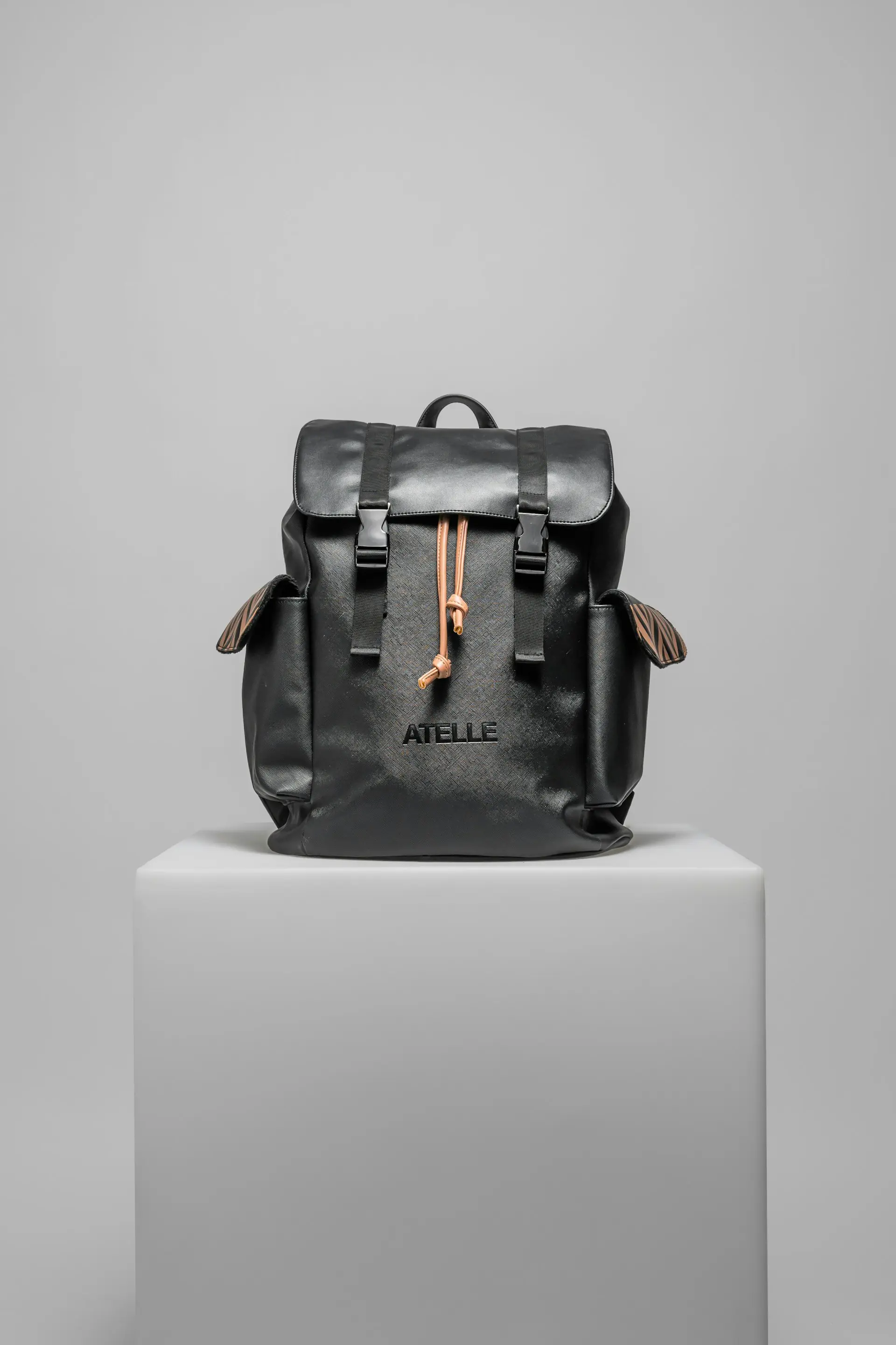 A black backpack staged on a white pedestal.