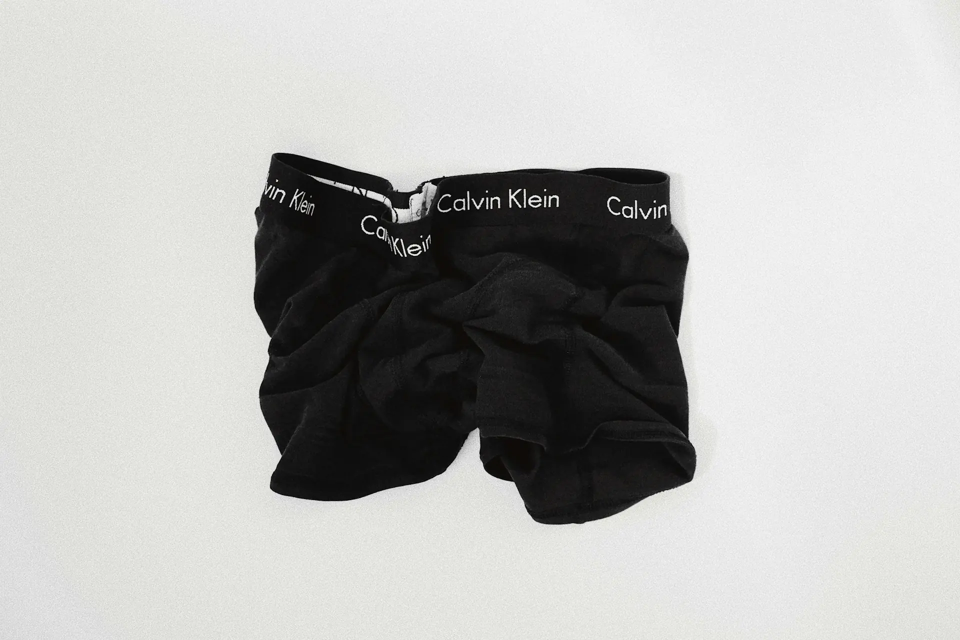 A folded pair of briefs on a white surface.