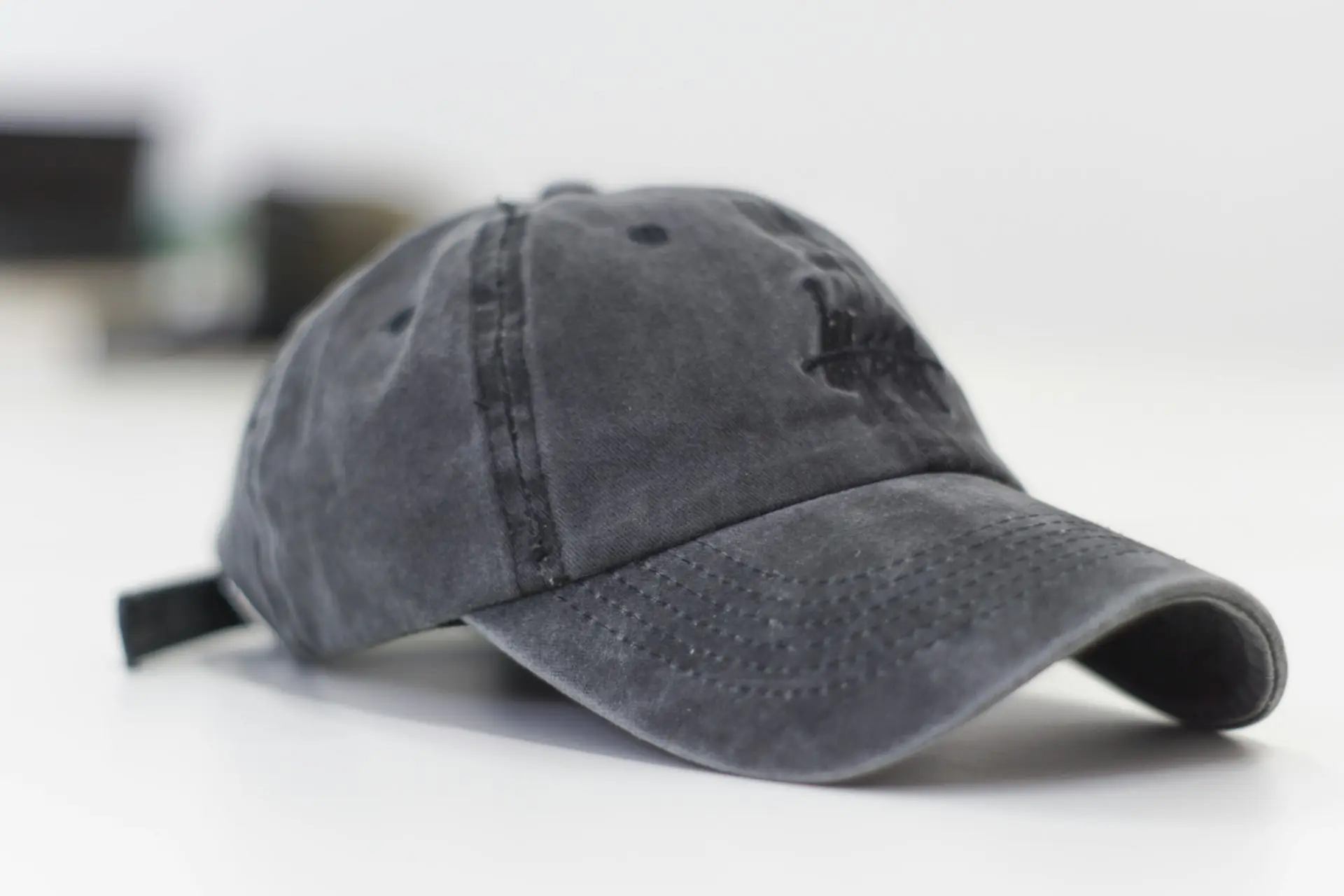 A grey six-panel cap on a white surface.