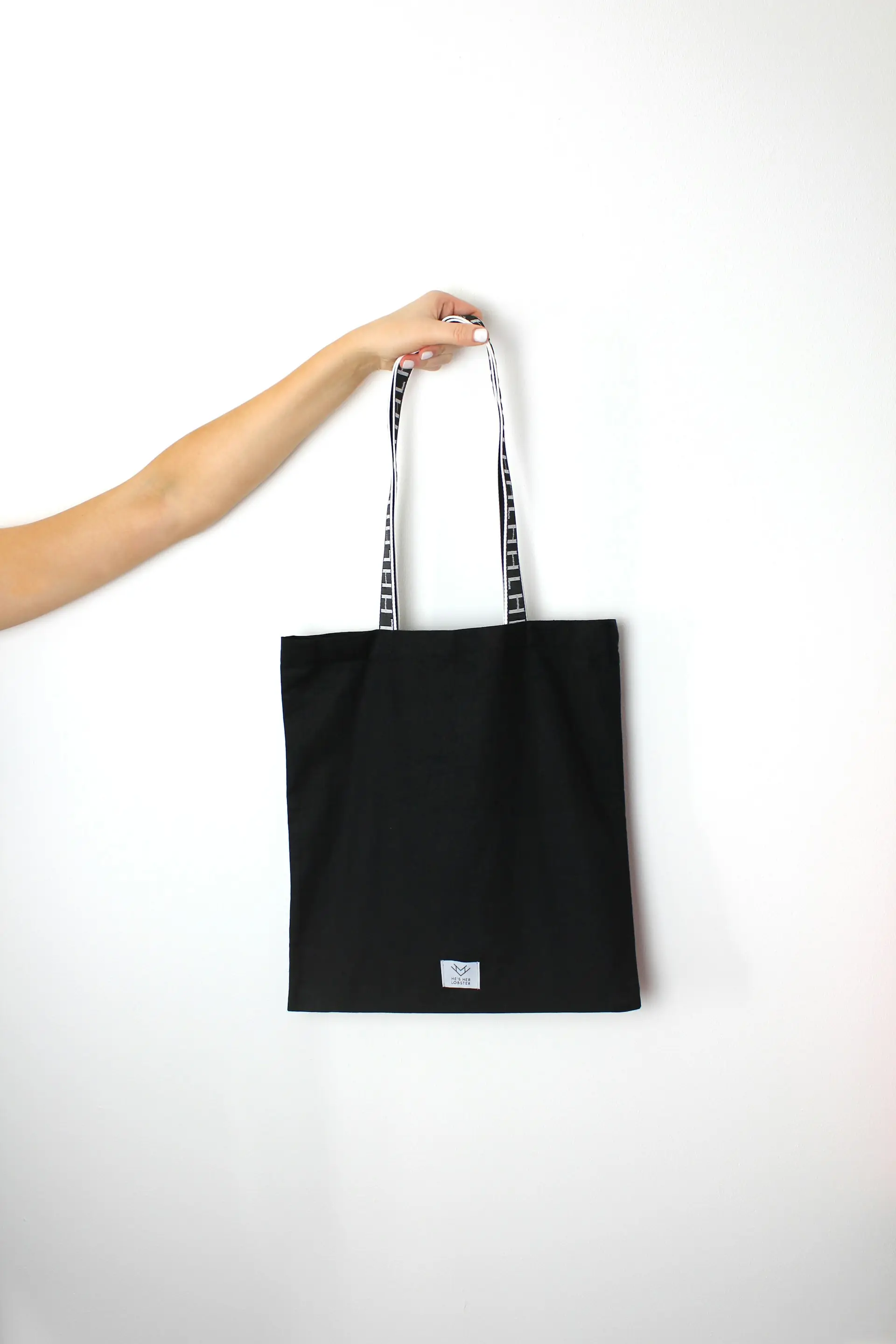 A black cotton tote against a plain ground.