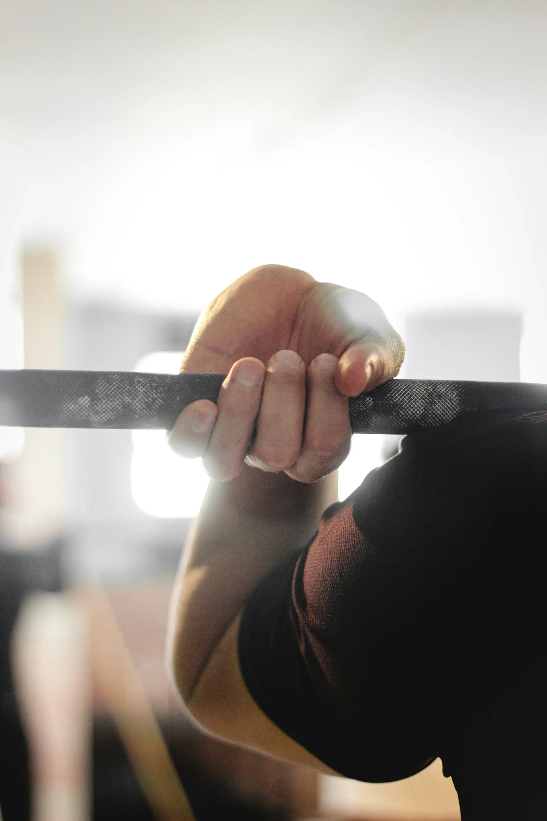 A chalked hand gripping the bar.