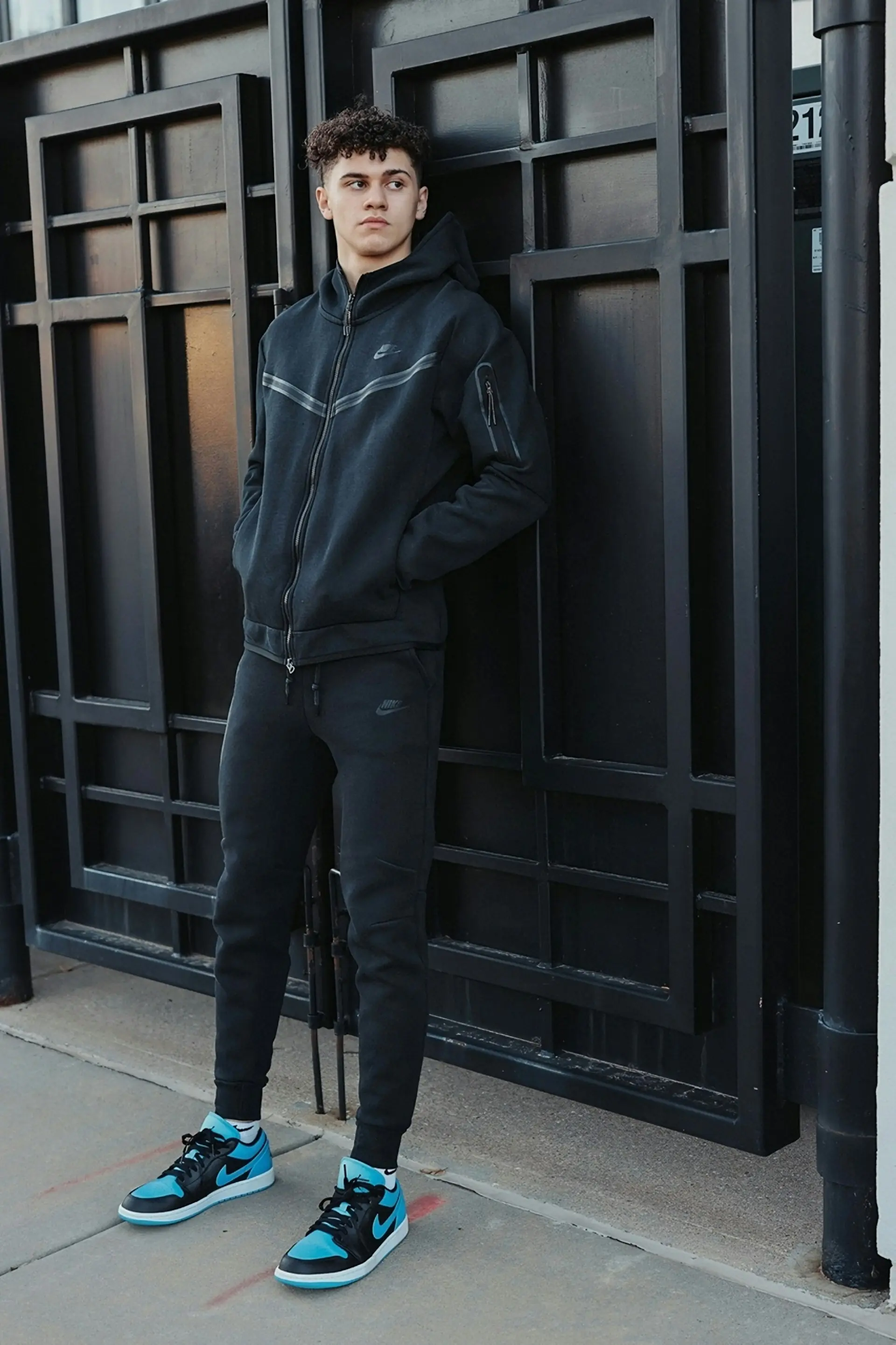 A man in a black tracksuit and sneakers.