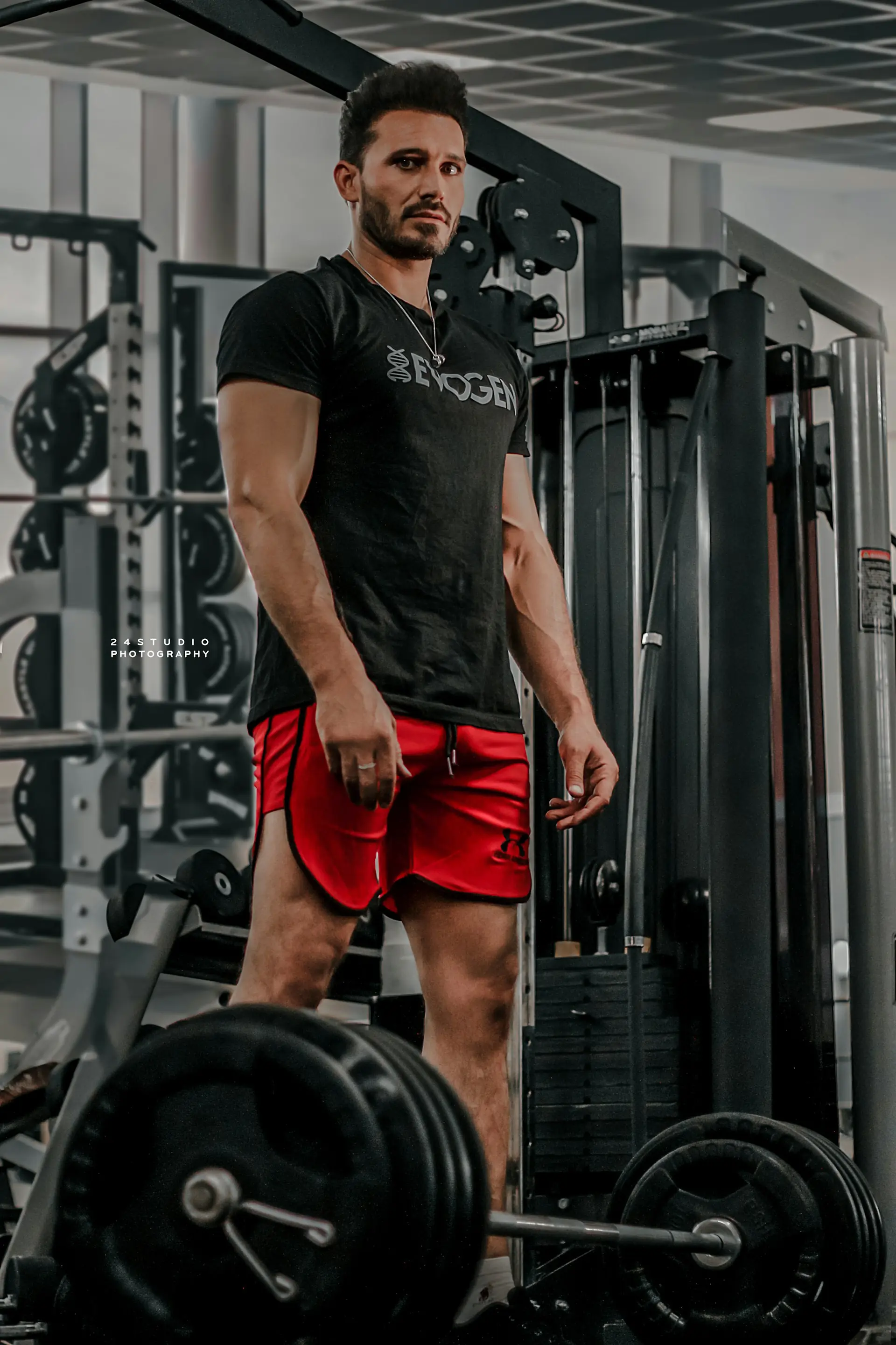 A man at a gym machine in training shorts.