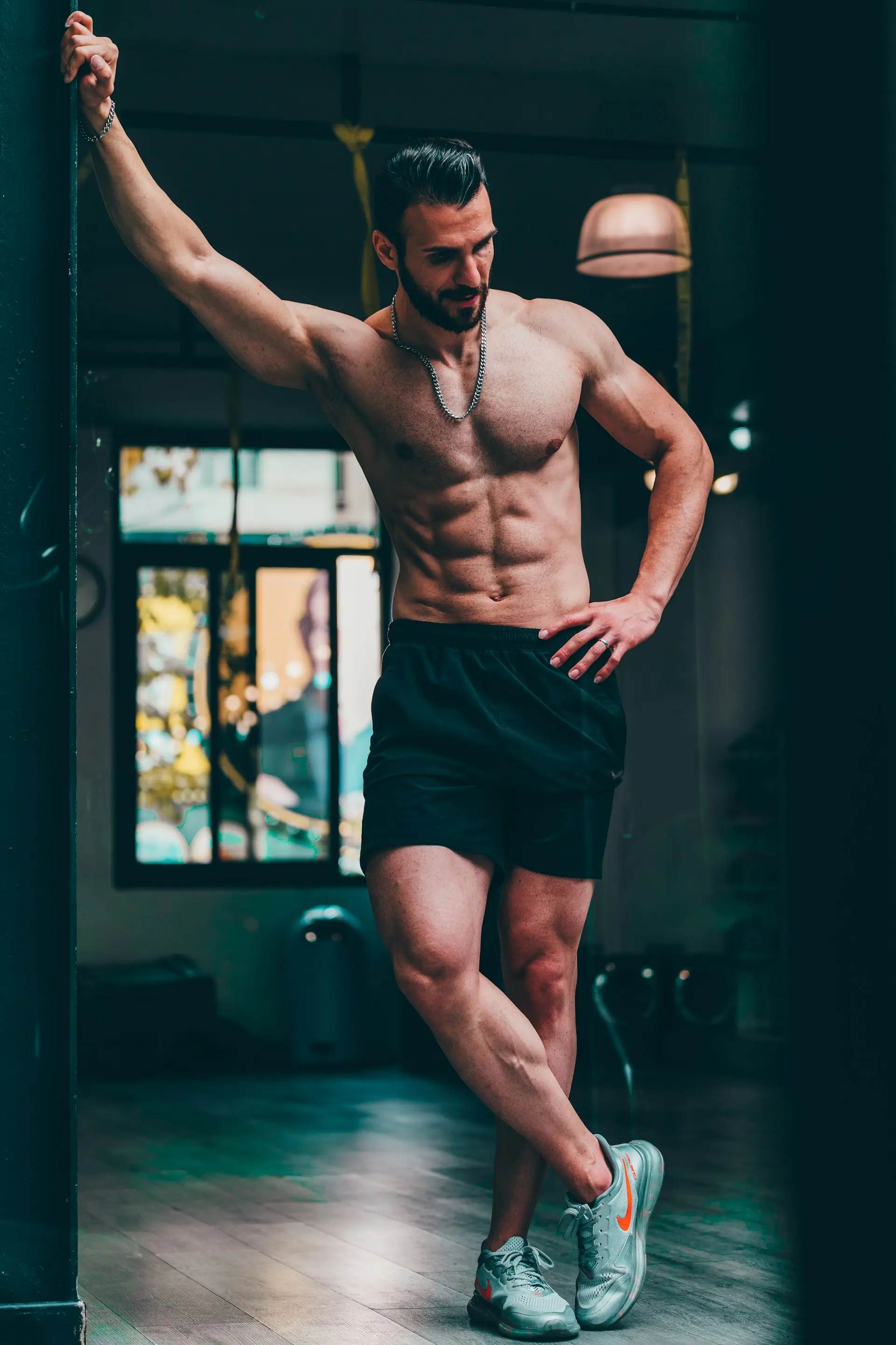 A man holding a basketball in mesh shorts.