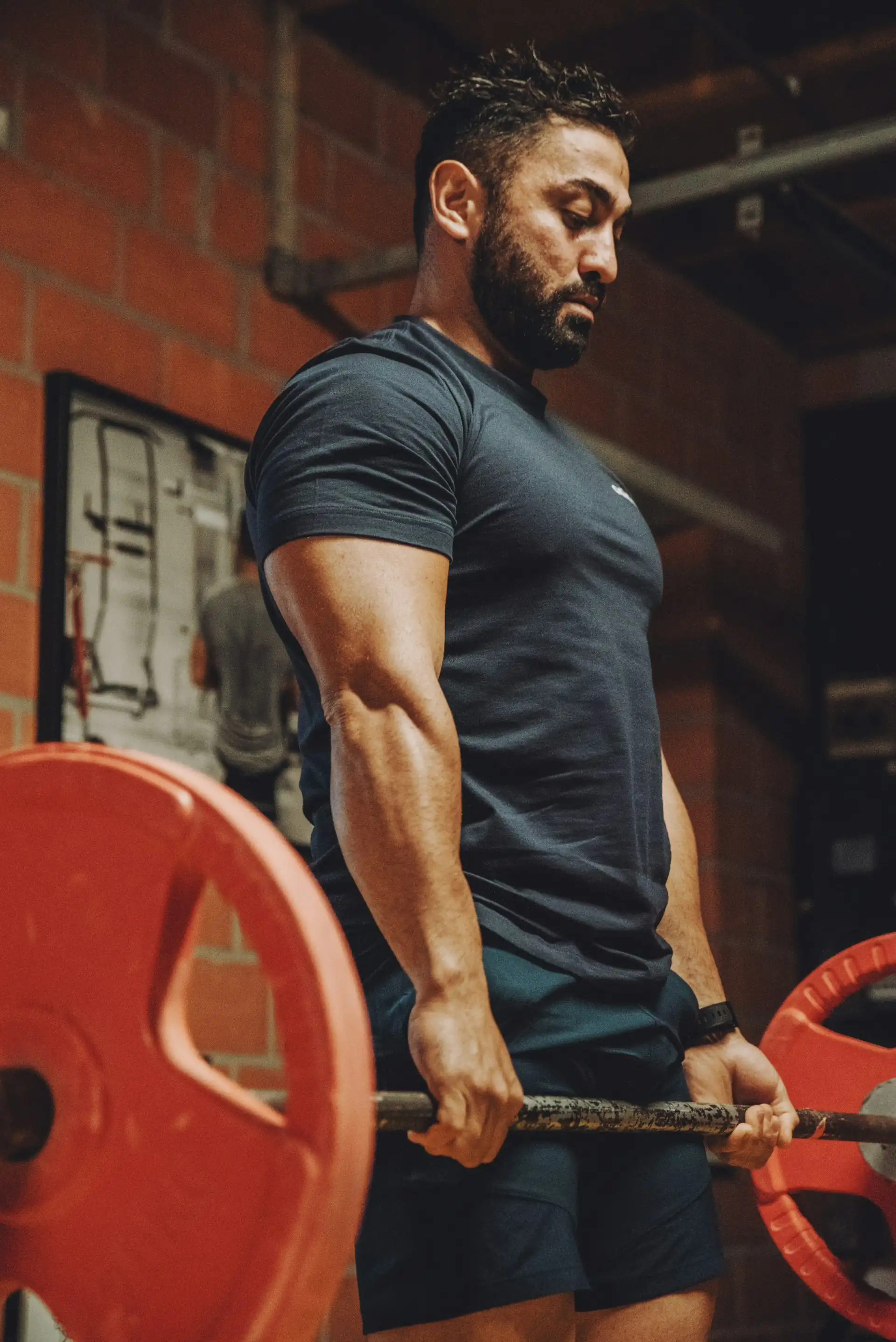 A man in an oversized black tee and jeans, seated.