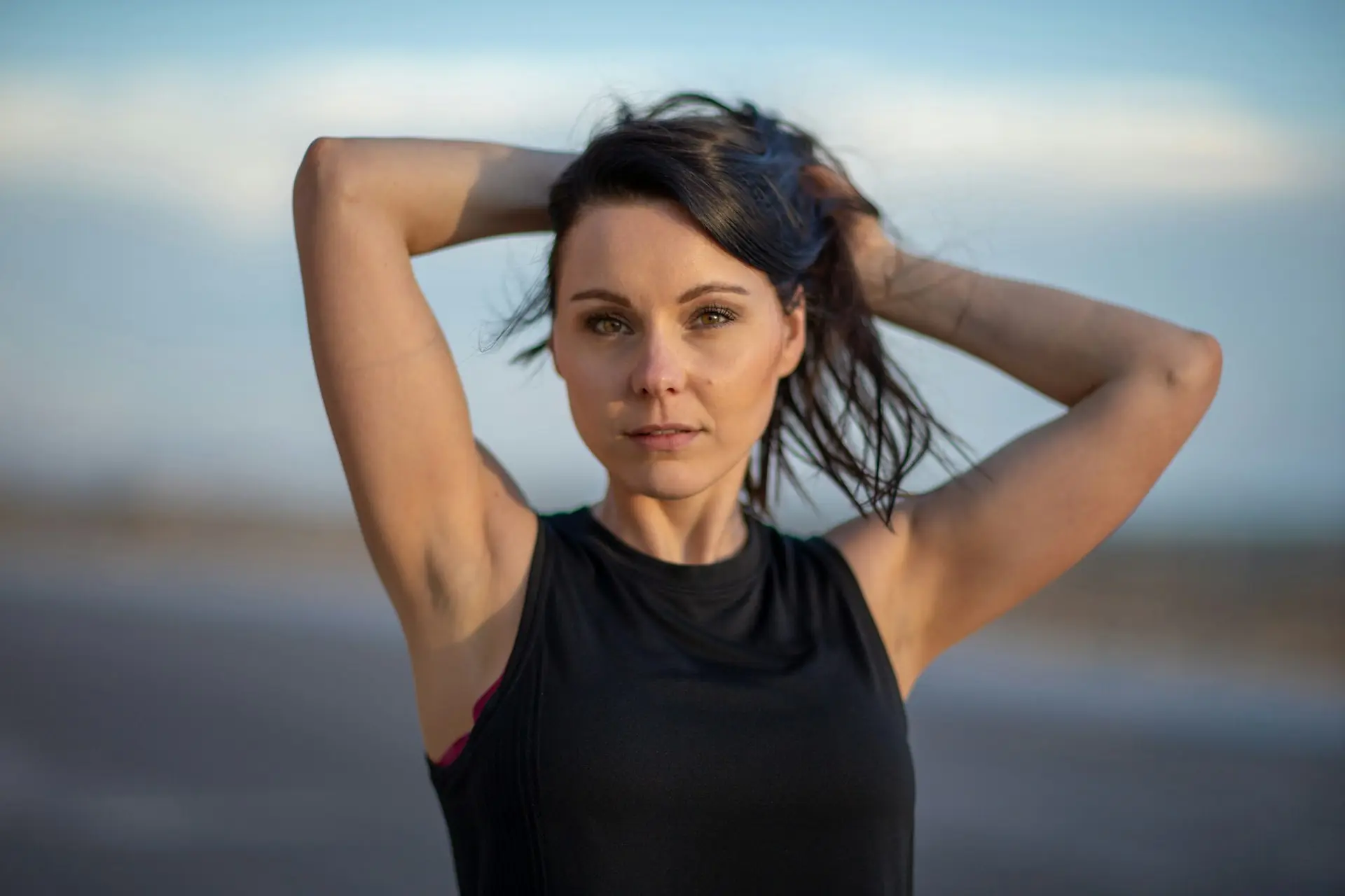 A woman in a black tank, studio portrait.