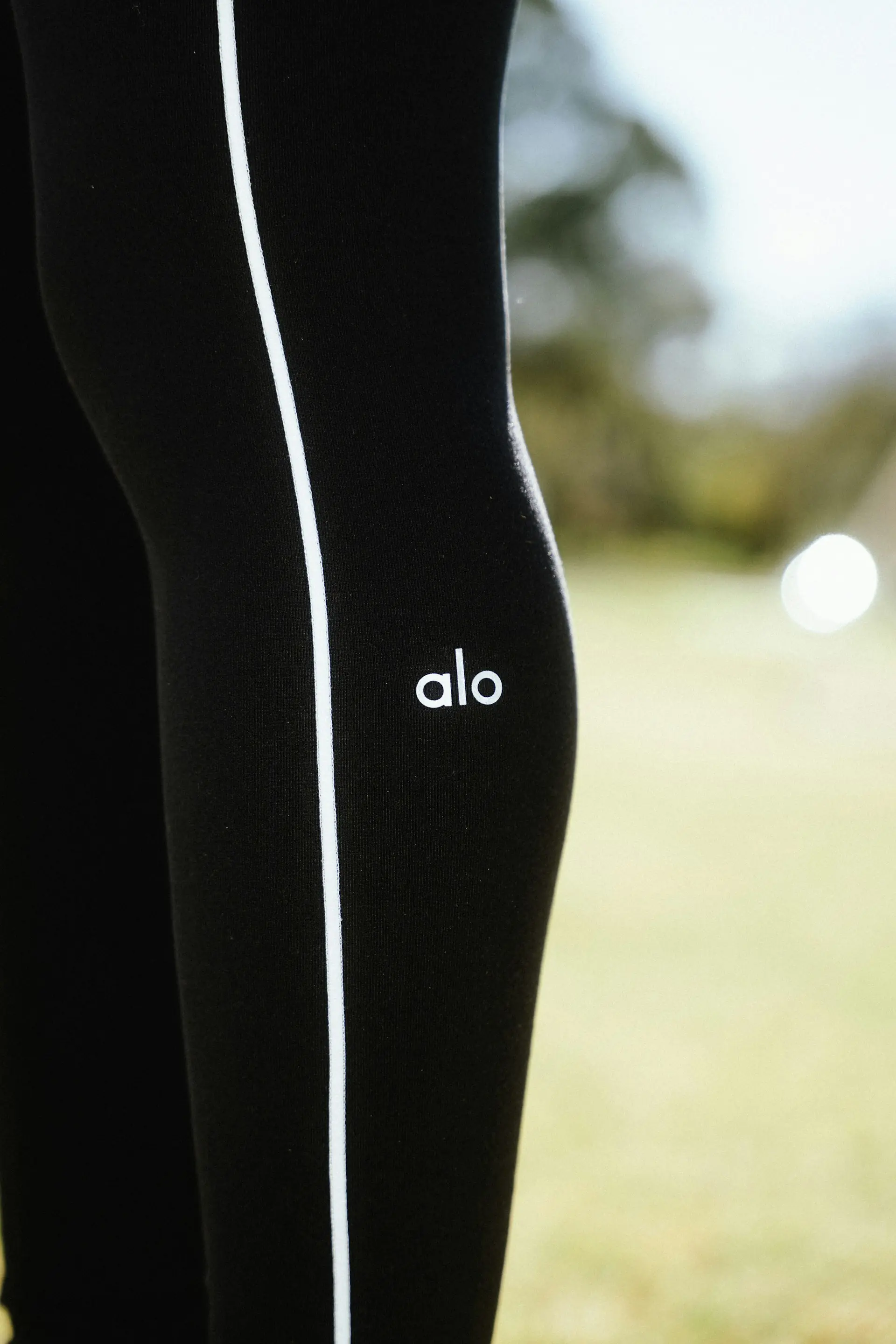 Black training leggings with a contrast stripe, up close.