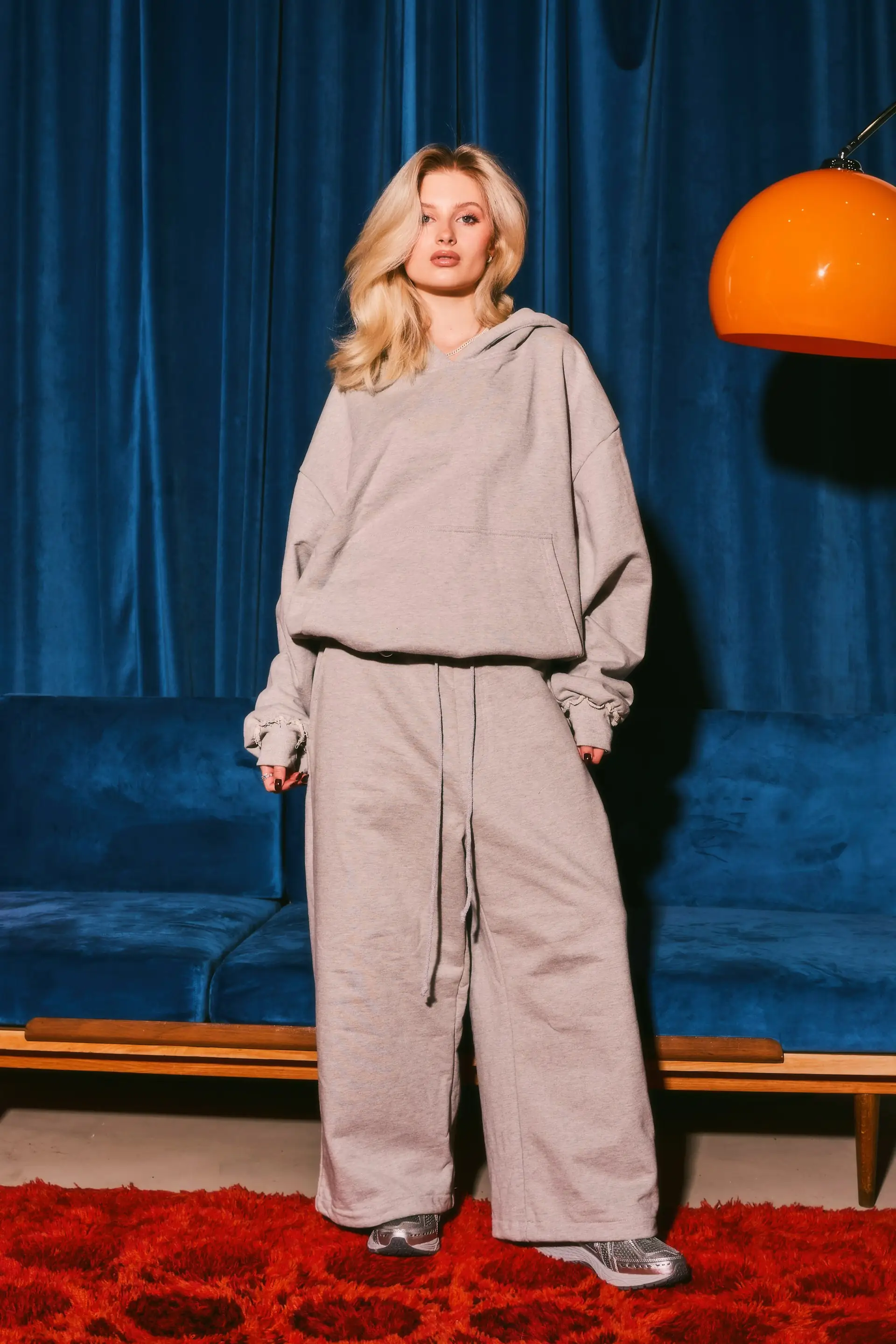 A woman in a grey tracksuit with wide pants.
